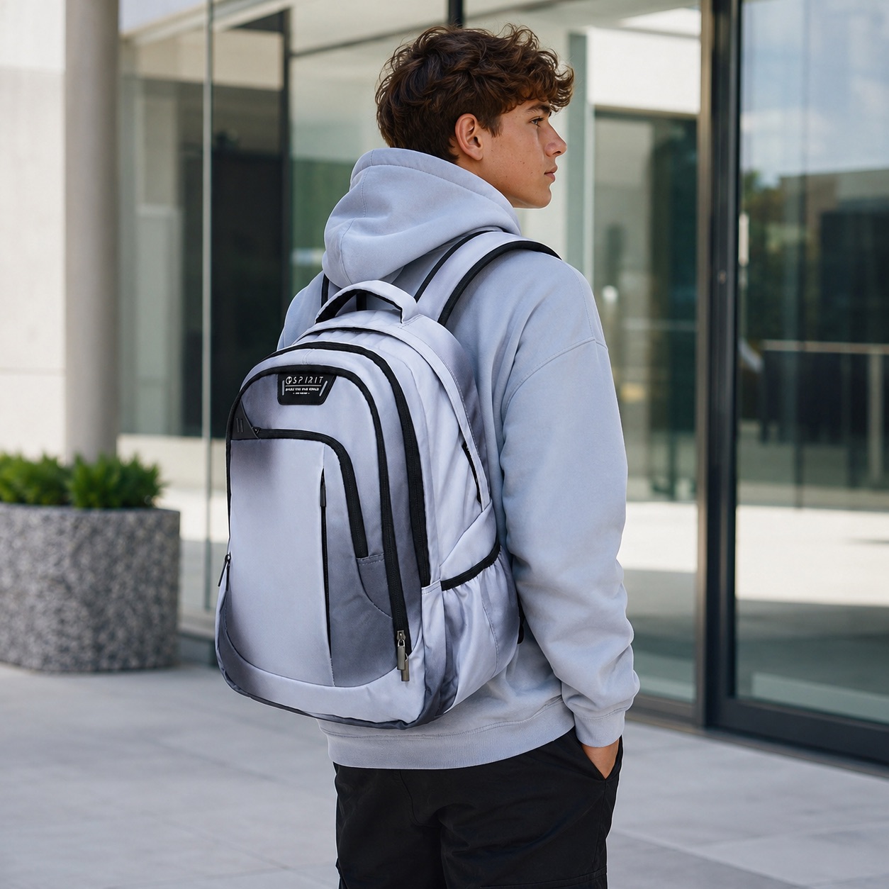 Ragazzo che indossa lo zaino scuola Spirit City Hazy Grey grigio sfumato all'aperto