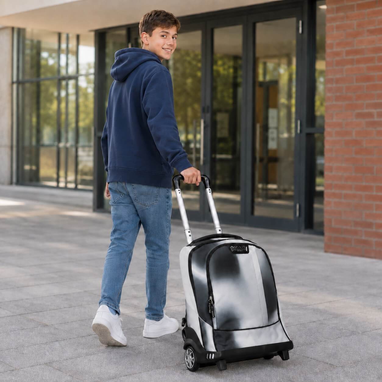 Ragazzo che trascina il trolley scuola Spirit City Hazy Grey davanti all'ingresso della scuola