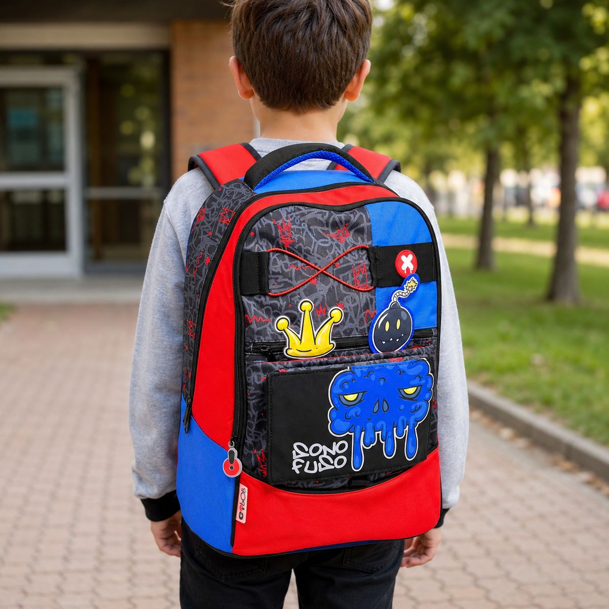 Bambino di spalle che indossa lo zaino scuola GoPop Nightmare davanti all'ingresso della scuola