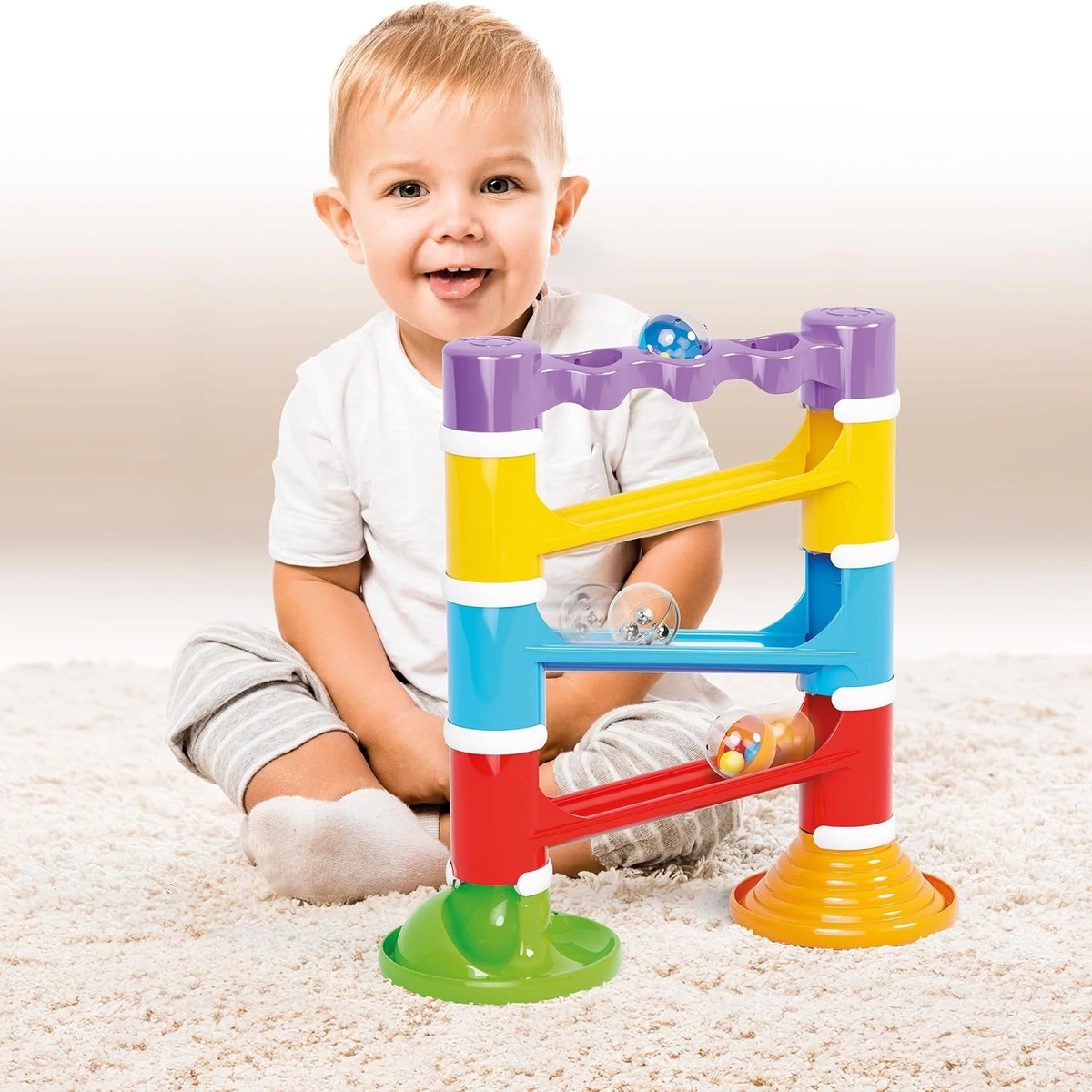 Bambino seduto che gioca con la pista Migoga Tower Sound
