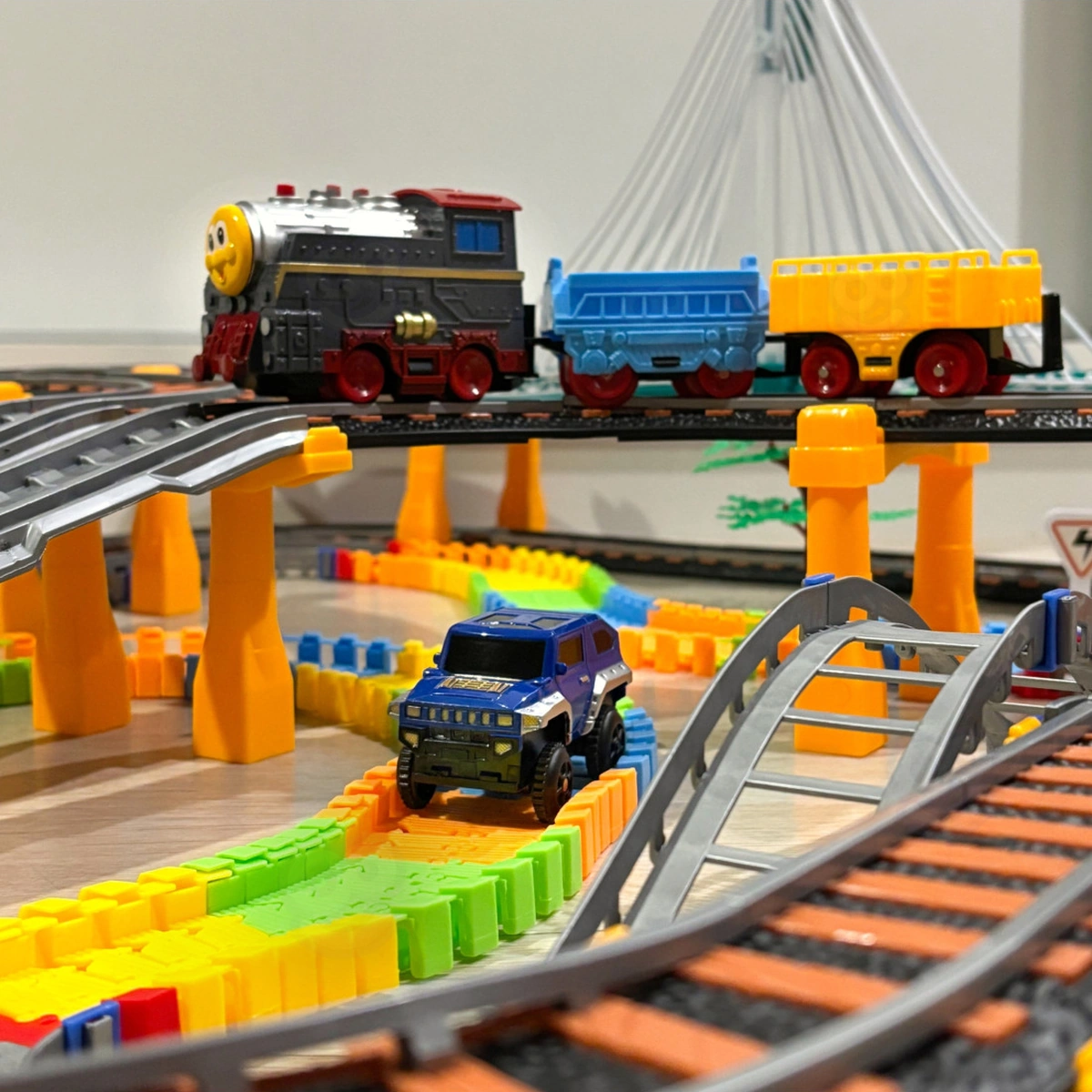 Locomotiva con vagoni sul livello superiore e auto sul percorso inferiore