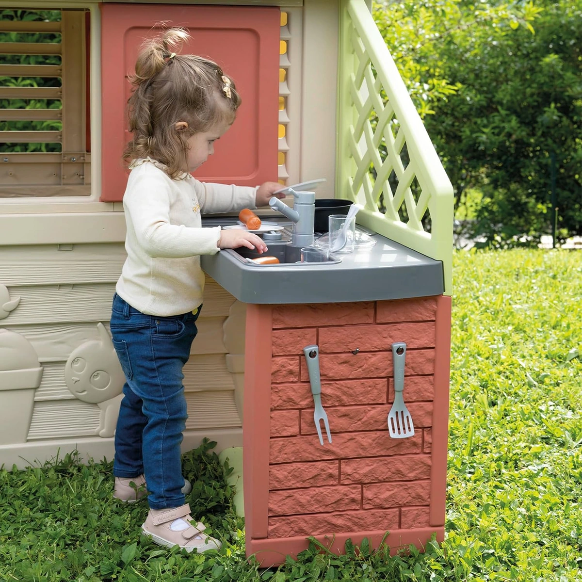 Bambina gioca con lavello e stoviglie della cucina esterna Smoby Life