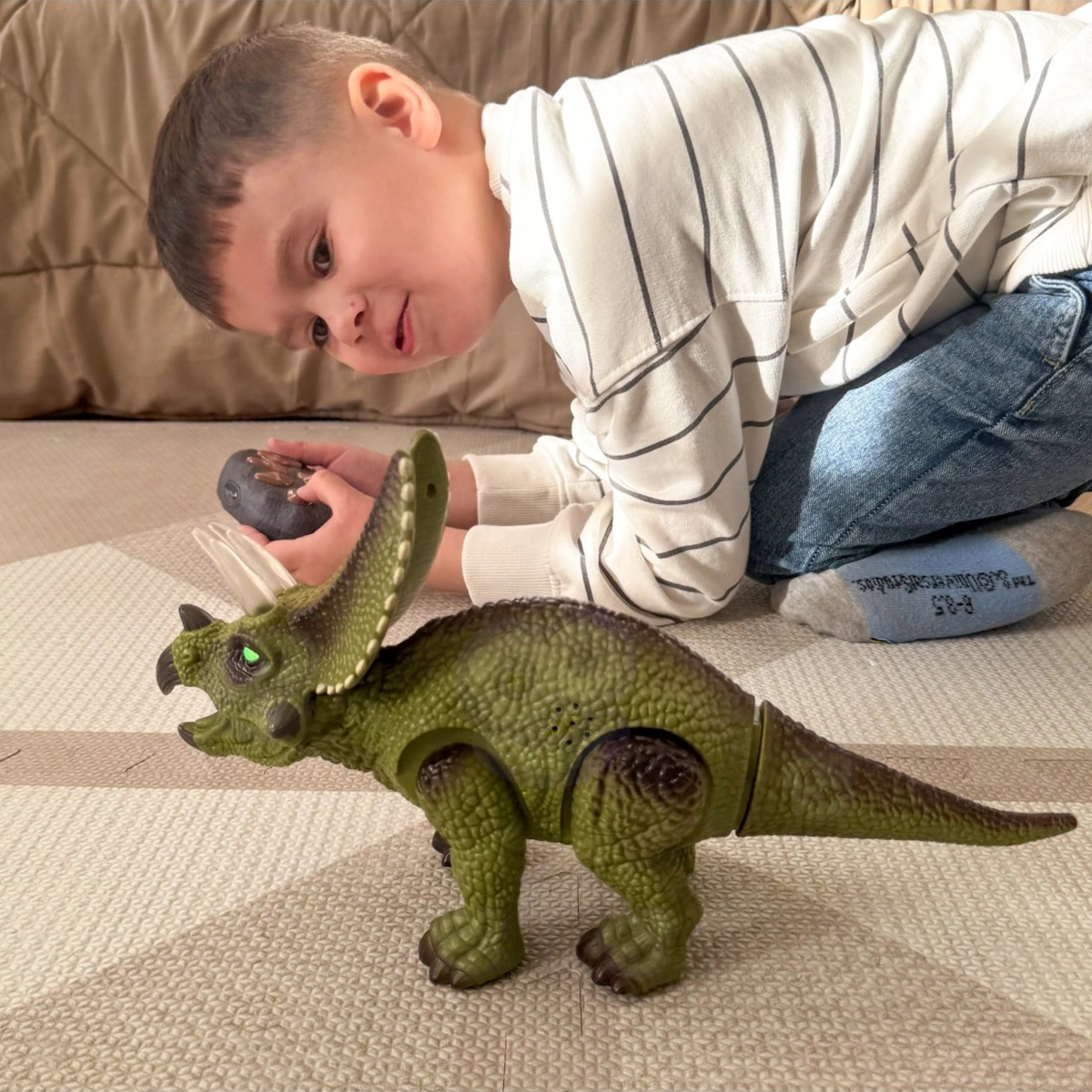 Bambino gioca con il triceratopo Woopie