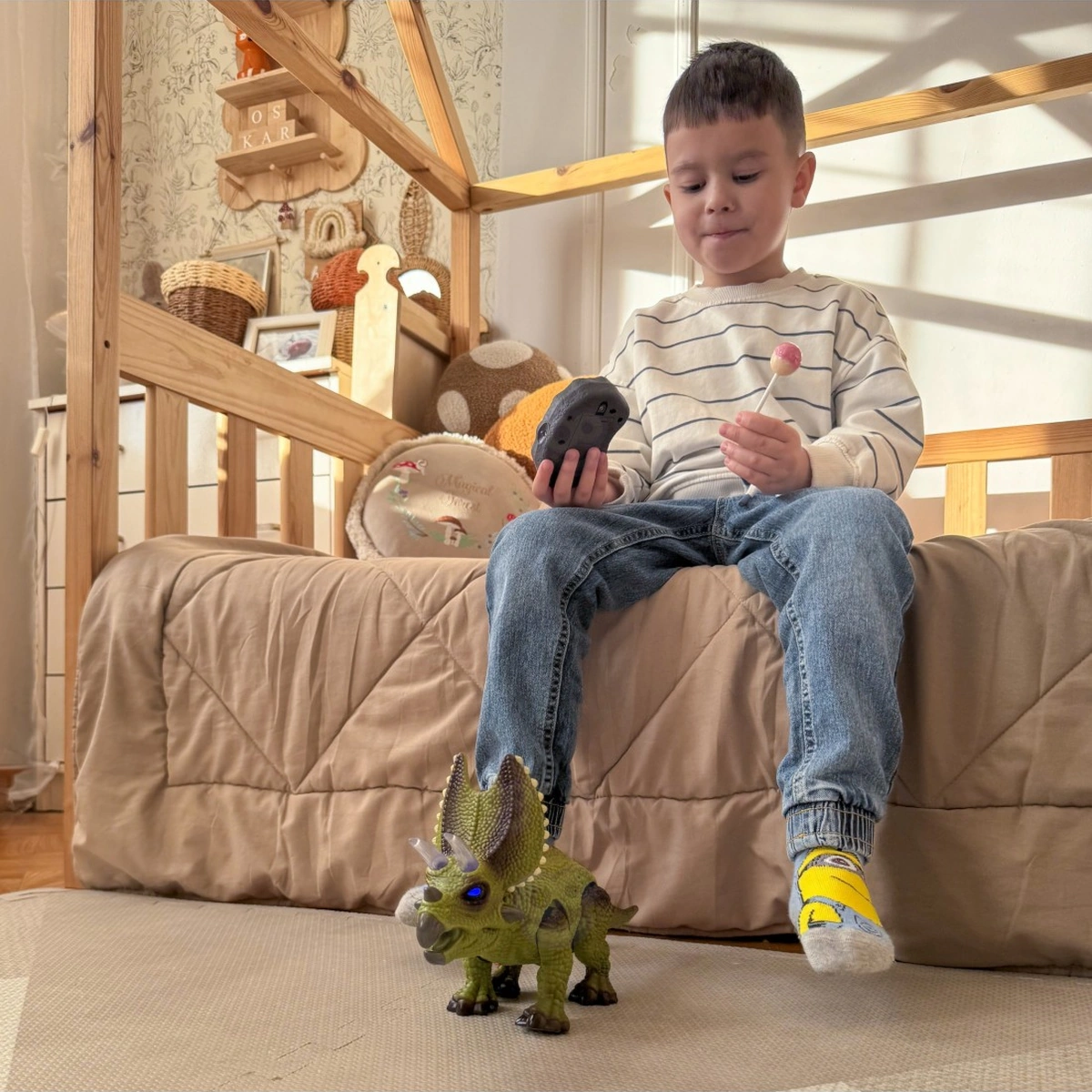 Bambino usa il telecomando per guidare il triceratopo