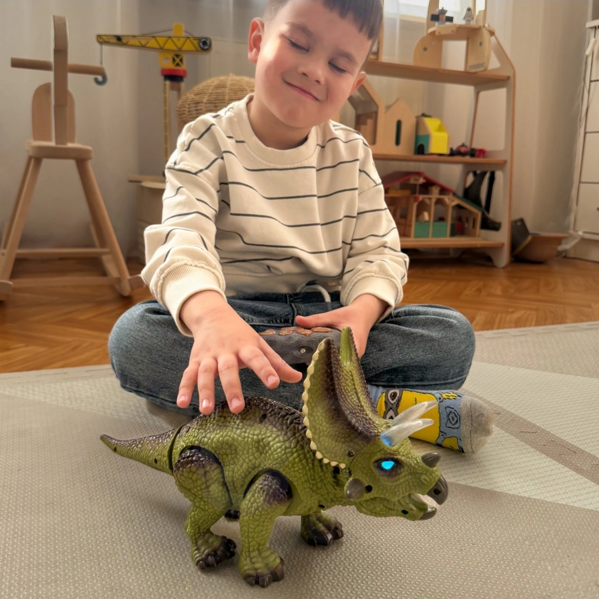 Bambino e triceratopo sul tappeto